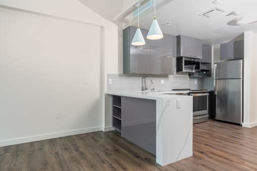 A kitchen with a white countertop and stainless steel appliances.