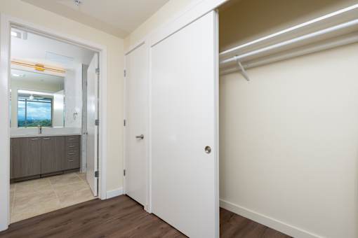 A white door is open to a room with a wooden floor.