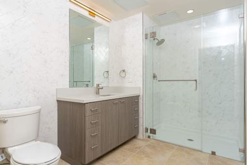 A bathroom with a toilet, sink, and shower.