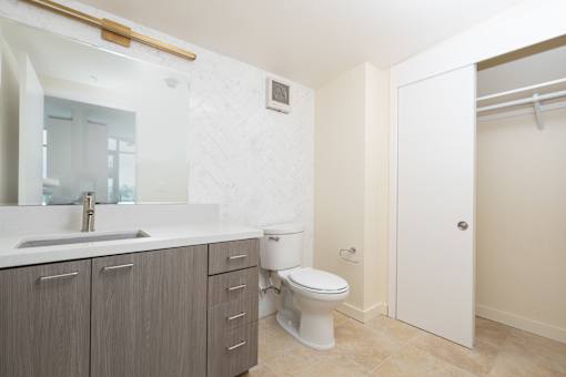 A bathroom with a sink, toilet, and a white cabinet.