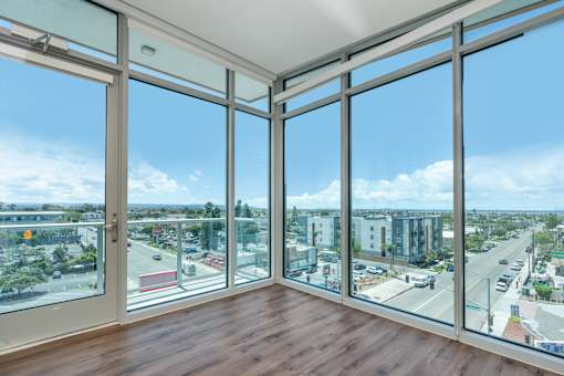 A room with a view of a cityscape through large windows.
