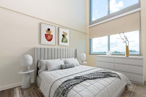 A bedroom with a large bed and two framed pictures on the wall.