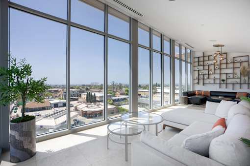 A living room with a view of the cityscape outside the large windows.