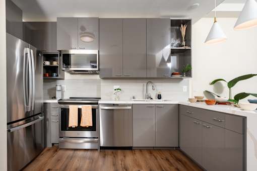 A modern kitchen with stainless steel appliances and wooden floors.