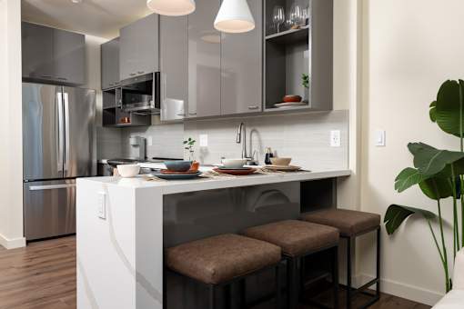 A modern kitchen with a white island and stools.