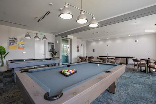 A pool table with a green cloth and a set of balls in the middle.