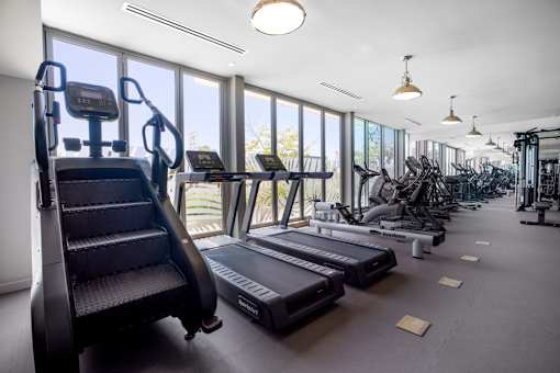A gym with treadmills, elliptical machines, and a stair climber.