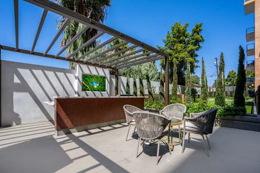 A patio with a table and chairs under a pergola.
