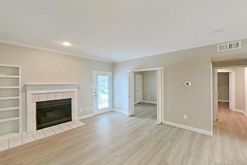 A living room with a fireplace and hardwood floors.