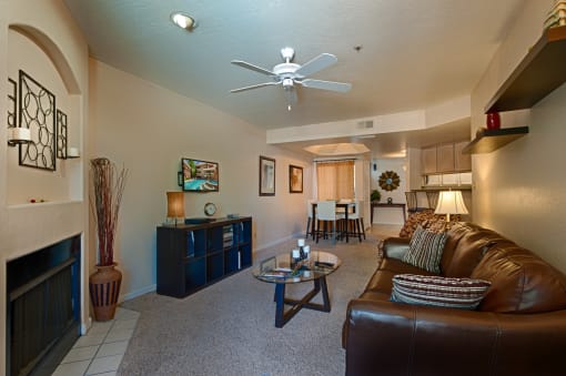 Apartments for Rent in Old Town Scottsdale - Cibola - Living Area with Grey Carpeting, Ceiling Fan, and Fireplace