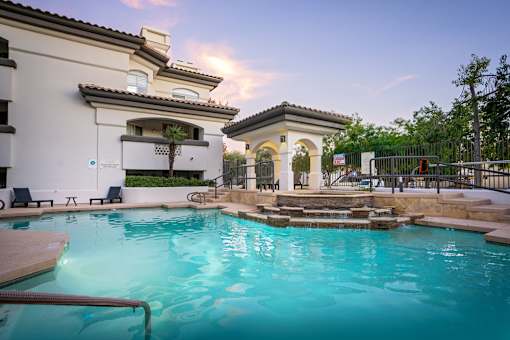 A swimming pool in a residential area with a building in the background.