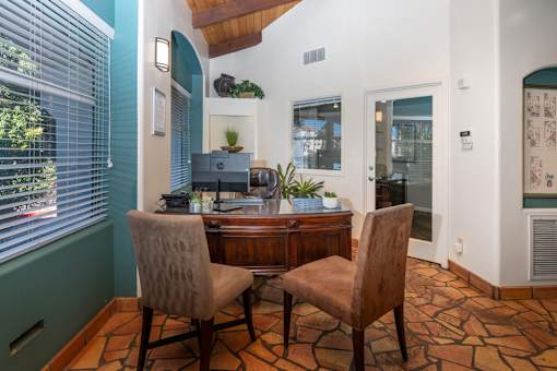 A room with a desk and two chairs.