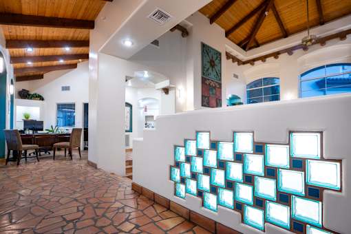 A wall of illuminated rectangles is on display in a room with a wooden ceiling.