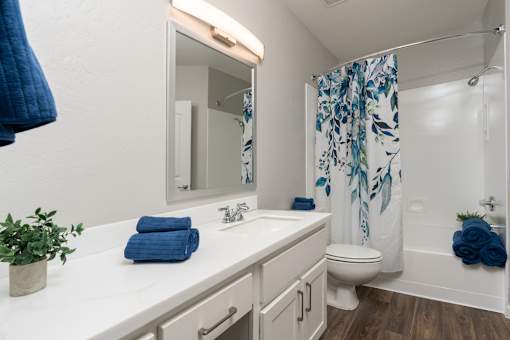 A bathroom with a white countertop and a white sink.