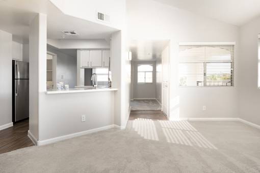 A kitchen with white cabinets and a refrigerator is visible.