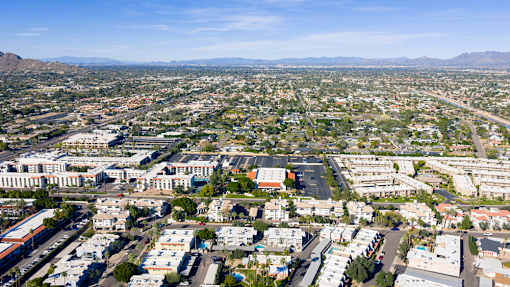 A cityscape with buildings and roads under a clear sky.