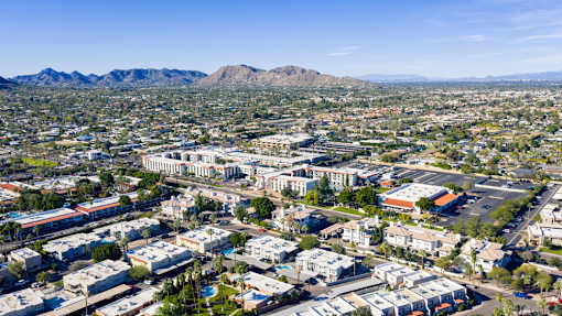 A cityscape with buildings and a mountain range in the background.
