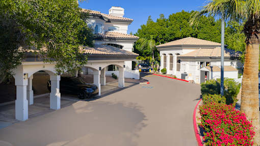 A black car is parked under a white building with a red trim.