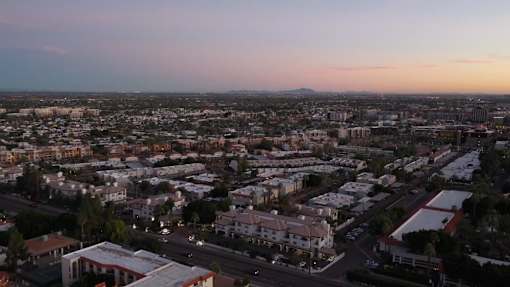 A cityscape at dusk with buildings and roads.