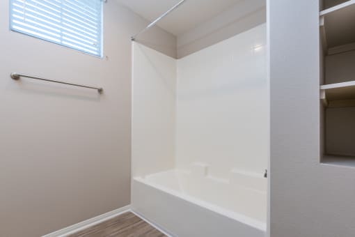 a bathroom with a white tub and a window