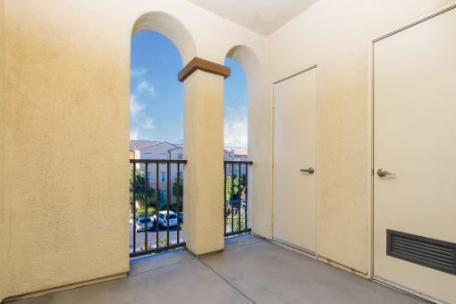 a balcony with two doors and a view of a parking lot