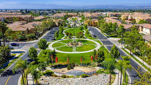 A view of a park in a residential area with a sign that says College Park.