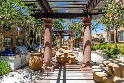 A patio with a table and chairs under a pergola.