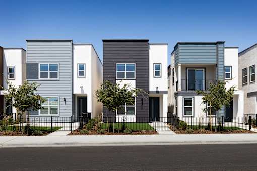 a row of townhomes with a street in front of them