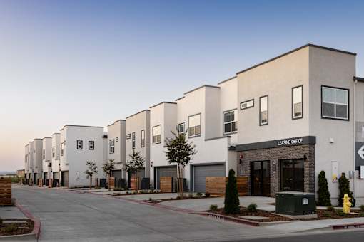 a row of townhomes with a street in front of them