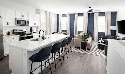 an open concept kitchen and living room with a large white island and black and white bar st