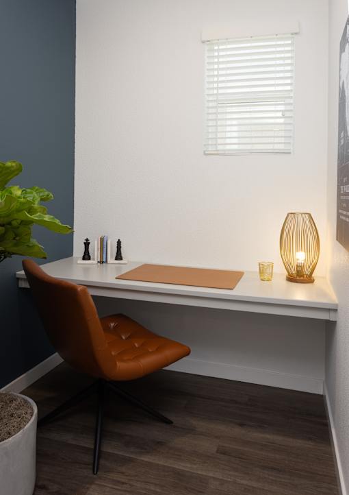 a home office with a white desk and a brown chair