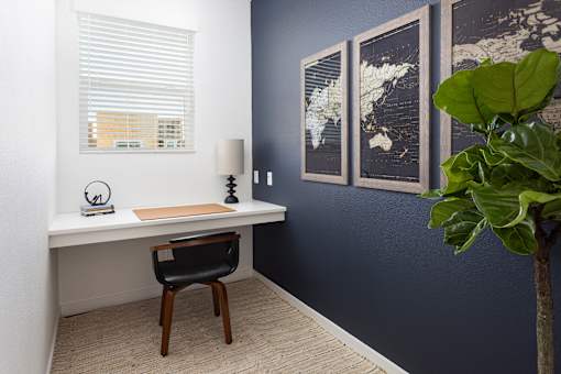 a desk with a chair and a lamp in a room with a blue wall