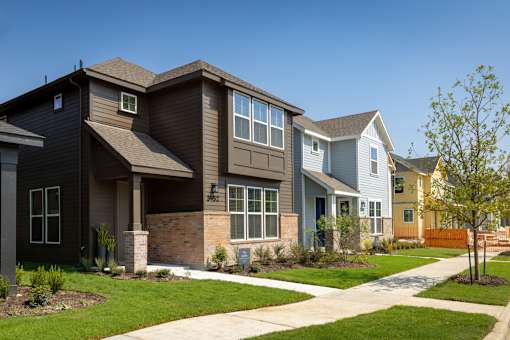 A row of houses with a tree in front of the first house.