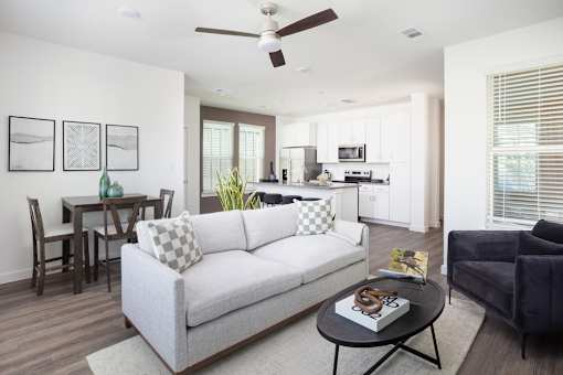 A living room with a grey couch and a black coffee table.