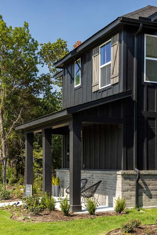 A black house with a white door and windows.