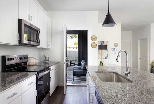 A modern kitchen with granite countertops and stainless steel appliances.