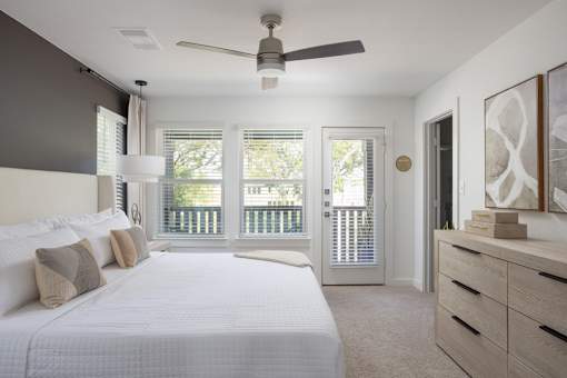 A bedroom with a large bed and a ceiling fan.