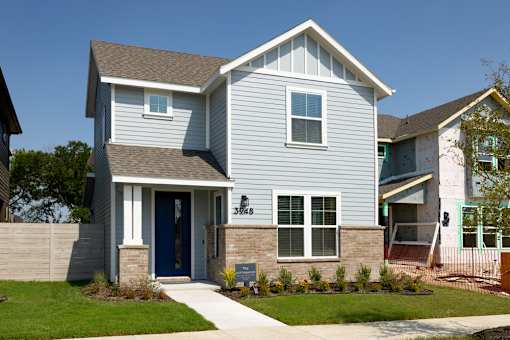 A house with a blue door and a grey facade.