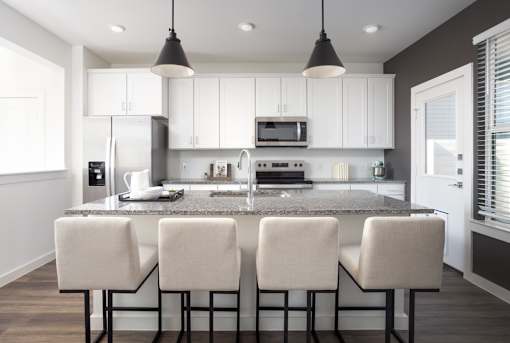 A modern kitchen with white cabinets and a granite countertop.