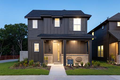 A modern house with a front yard and a walkway leading to the entrance.