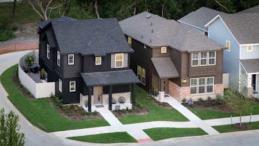A black house with a white fence in front.