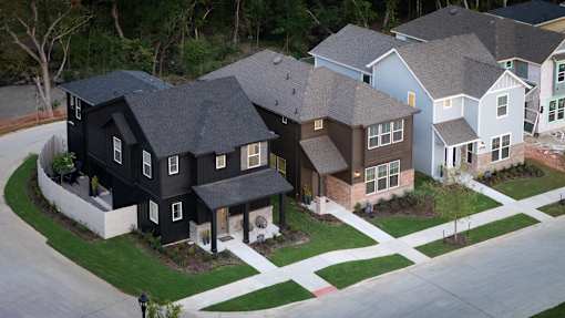 A black house with a white fence in front of it.
