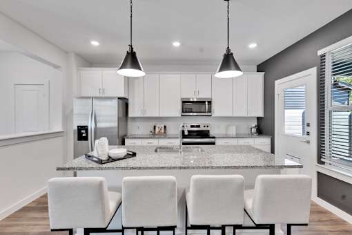 A modern kitchen with white cabinets and a central island.