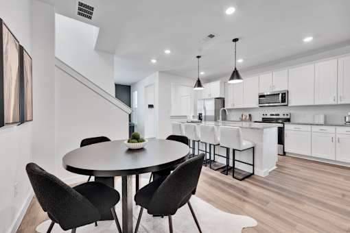 A modern kitchen with a dining table and chairs.