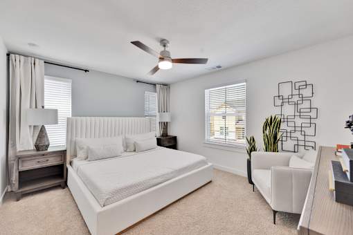 A bedroom with a large bed and a ceiling fan.