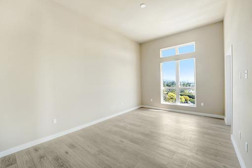 Empty room with a large window overlooking a landscape at Skyview Sunset Apartments, Los Angeles, California