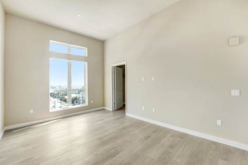 A room with a large window and a wooden floor at Skyview Sunset Apartments, California, 90046