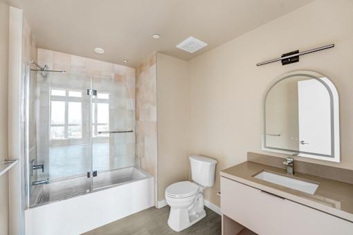 A bathroom with a toilet, sink, and shower at Skyview Sunset Apartments, Los Angeles 90046