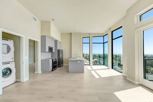 A spacious kitchen with a washing machine and a refrigerator at Skyview Sunset Apartments, Los Angeles, CA