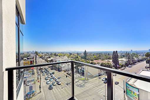 A view from a balcony overlooking a busy street with cars and buildings at Skyview Sunset Apartments, Los Angeles, CA, 90046